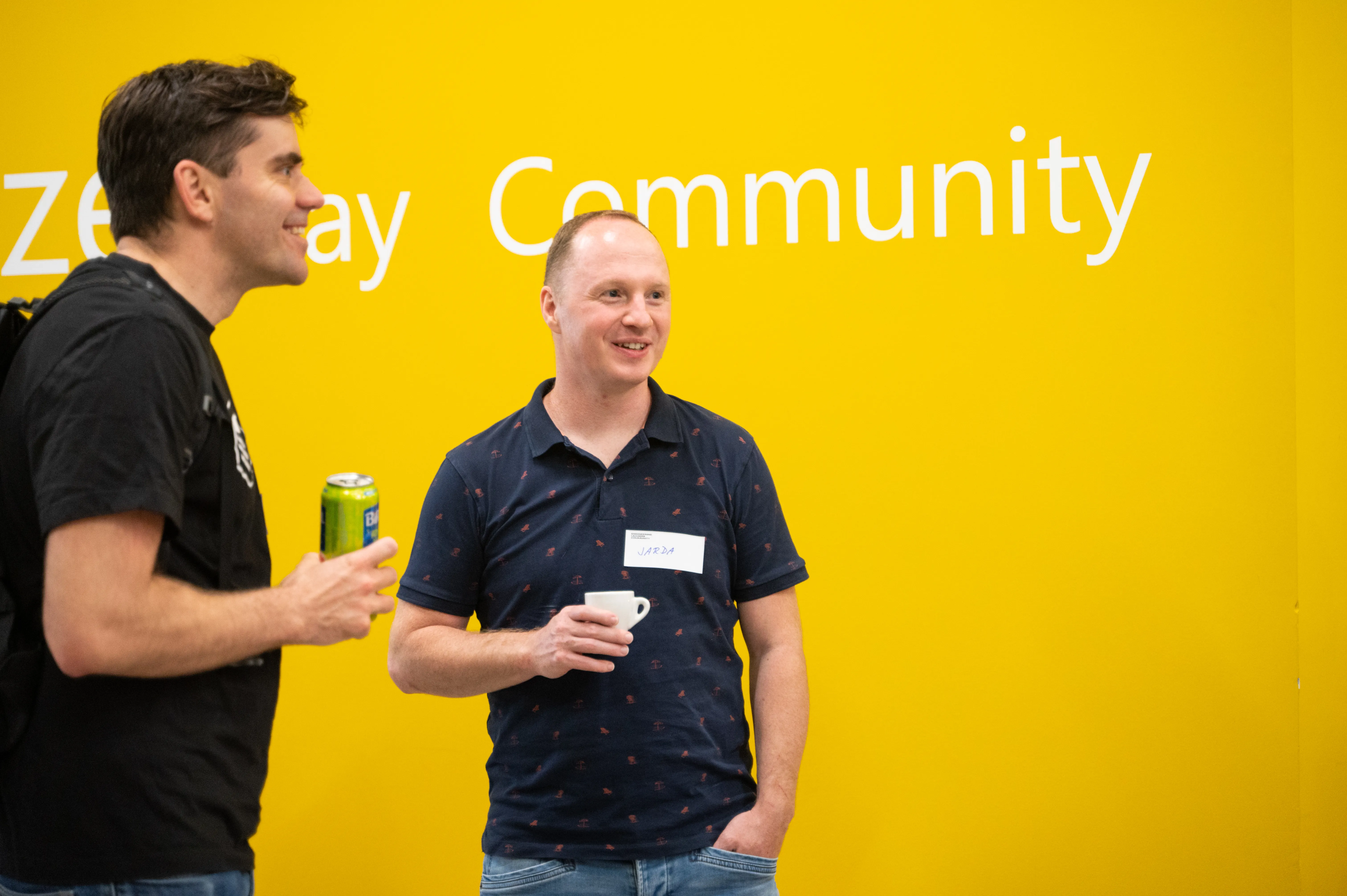 Two ELC members talking in front of a community wall at a meetup