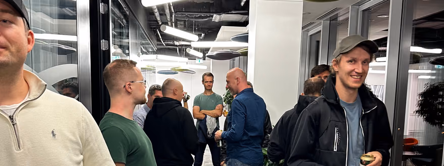 Attendees mingling with drinks and snacks in an office hallway at the ELC meetup in Bratislava