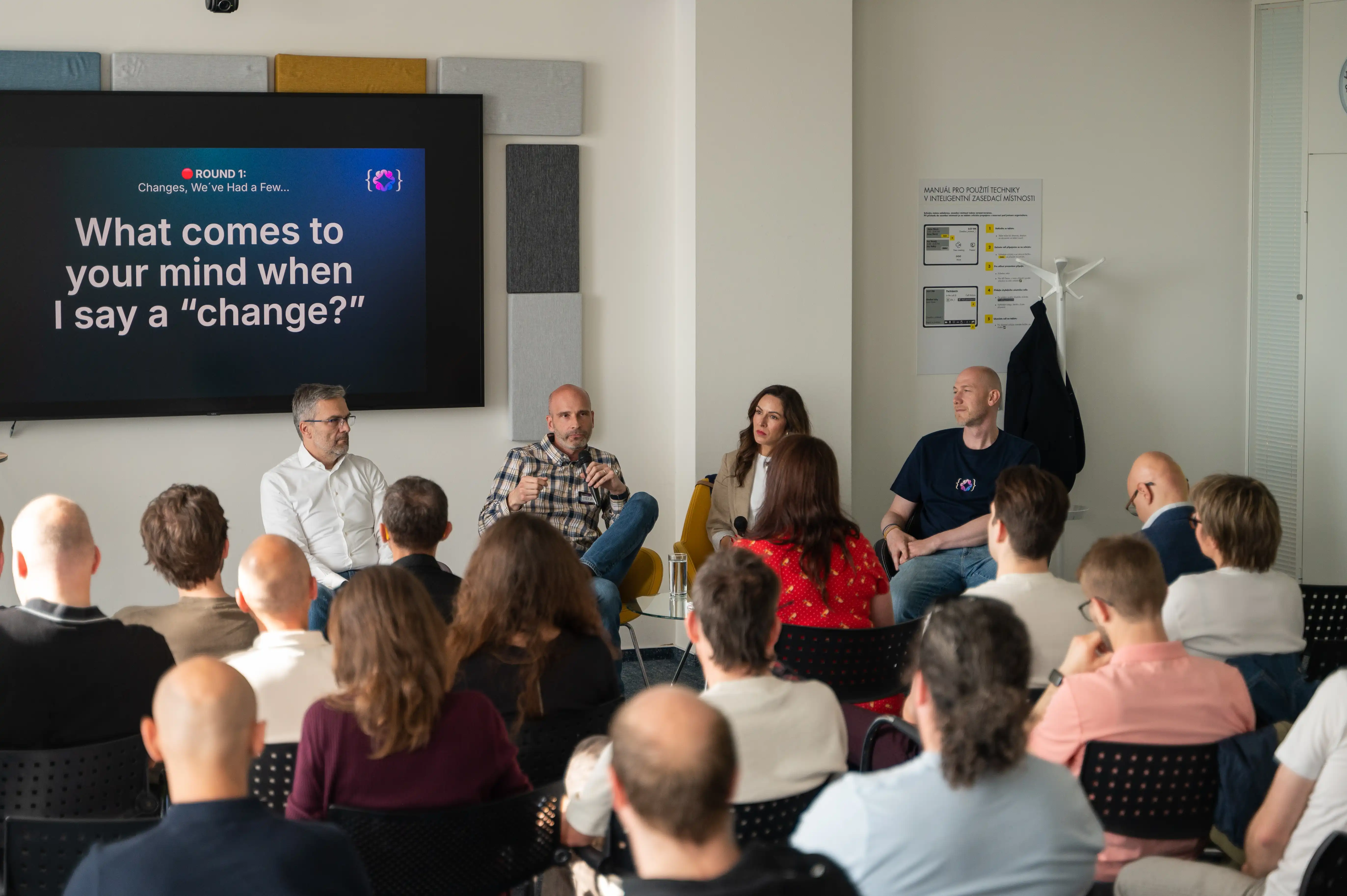 Four ELC panellists in conversation with a microphone in front of a seated audience