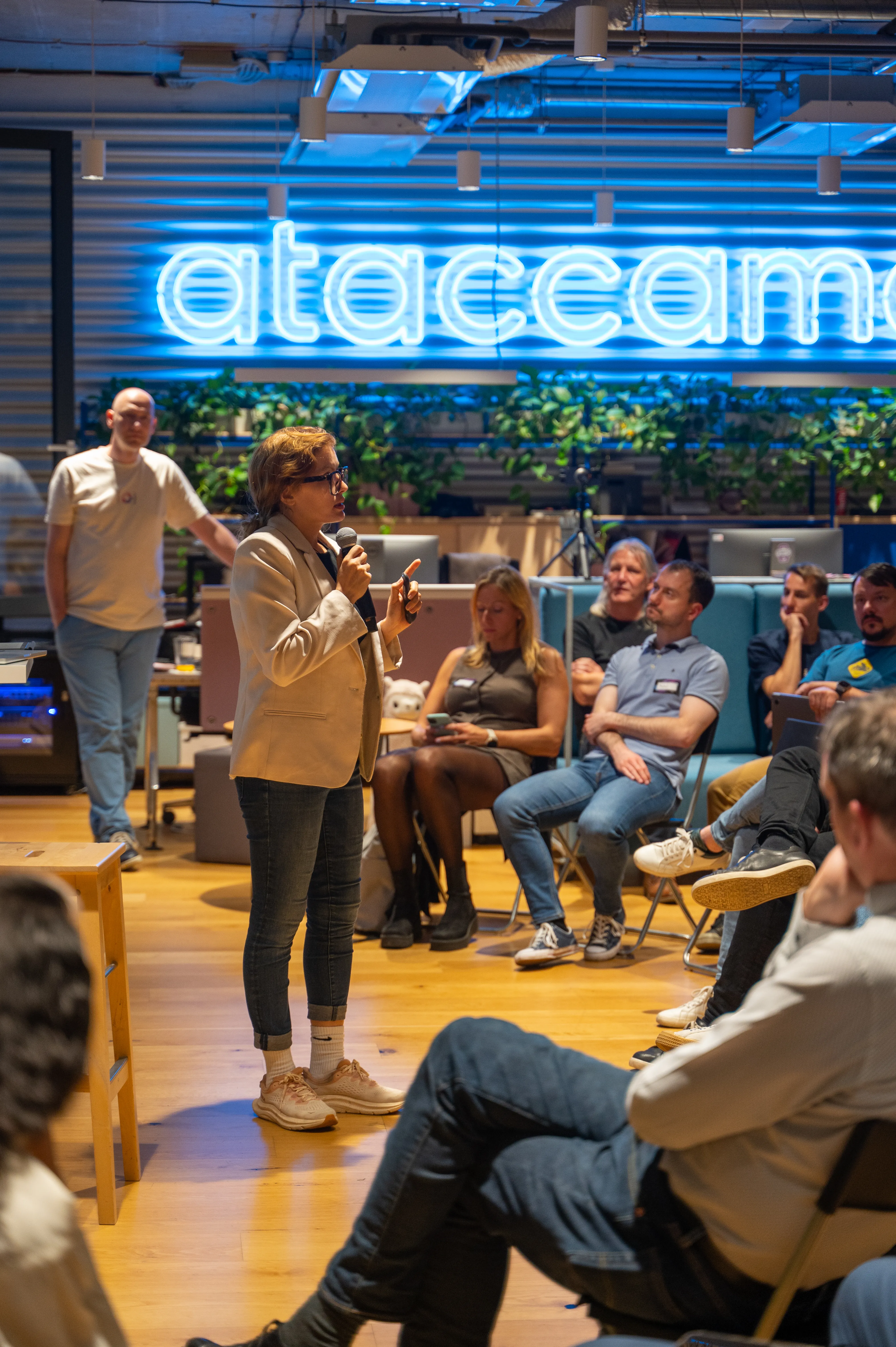 A speaker with a microphone addressing a small seated group at an ELC session