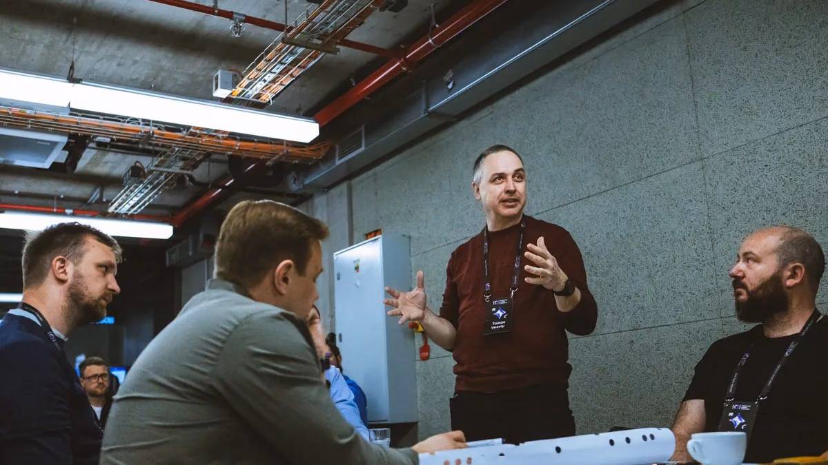 A facilitator talking with a small group of engineering leaders around a table at an ELC session.