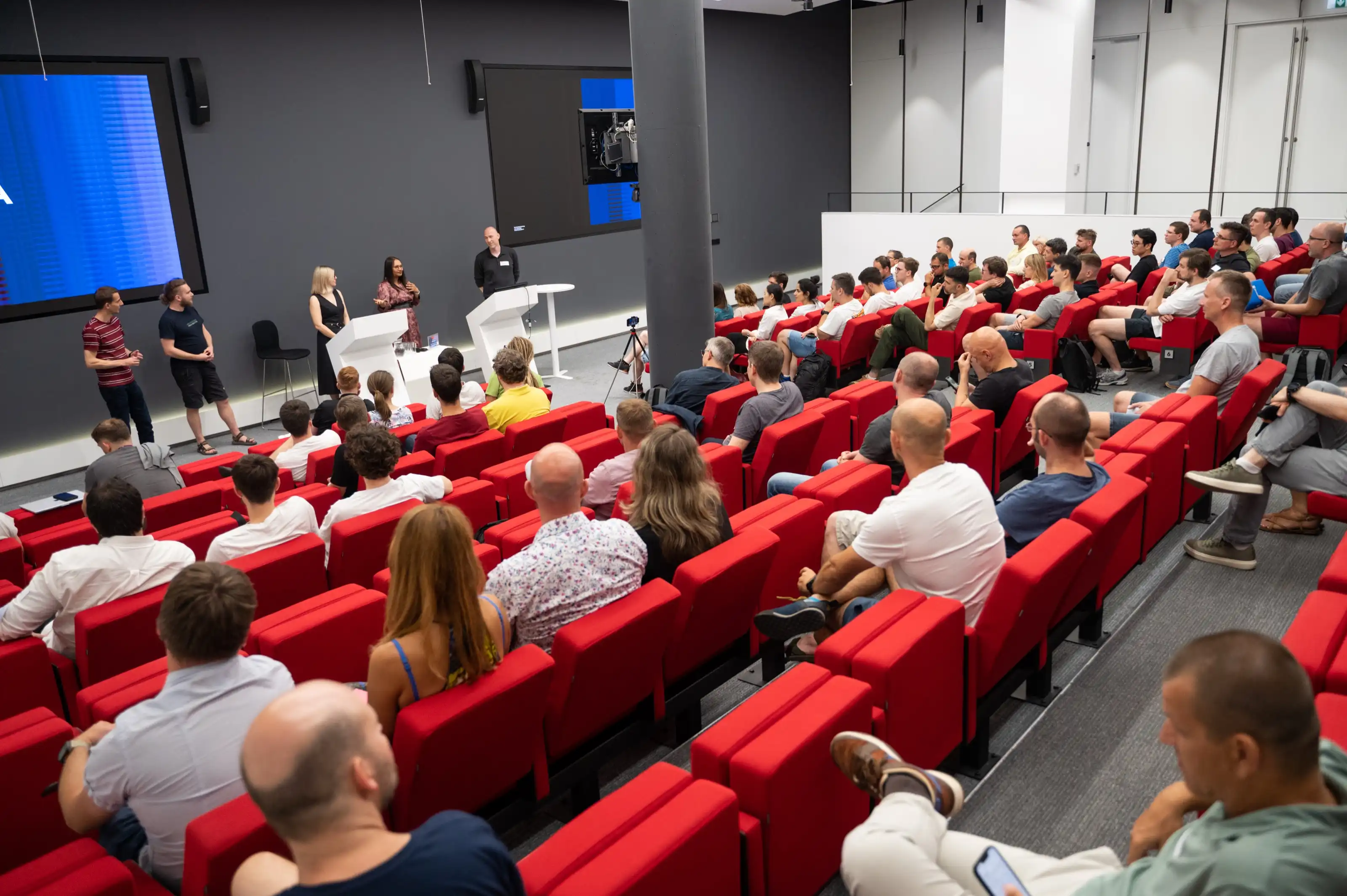 A packed auditorium of engineering leaders watching a talk at an ELC meetup, rows of attendees filling the room.