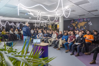 An ELC meetup hosted in a company office in Prague: a speaker with a microphone in front of a packed audience of engineering leaders.