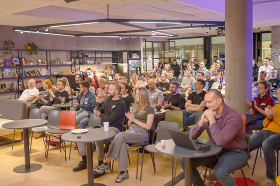 A packed ELC meetup in Prague: engineering leaders at round tables applauding a speaker, the kind of room where companies hiring in Czech Republic meet senior engineers.