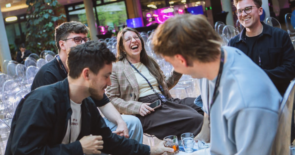 A group of engineering leaders laughing together on clear chairs at an ELC event, the icebreaker moment before the talks