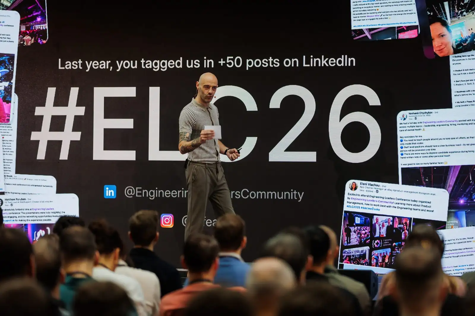 A speaker on the ELC Conference 2026 stage in front of a screen of LinkedIn posts tagging the event.