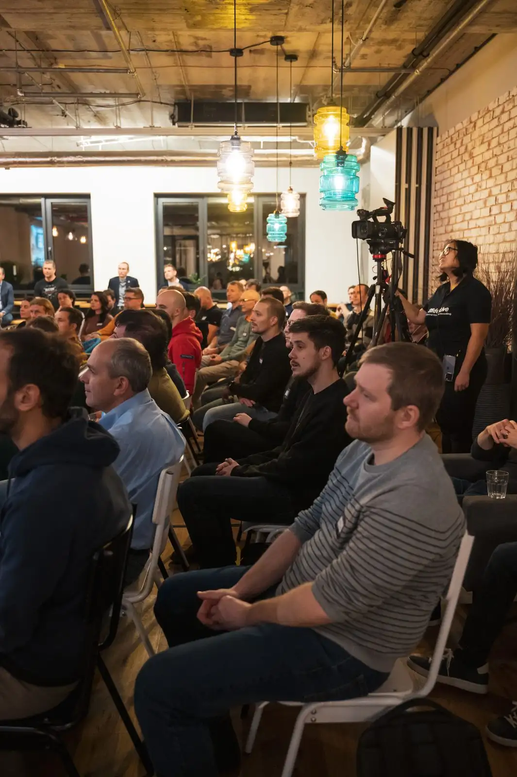 A full room of engineering leaders at an ELC meetup, a camera filming from the side.