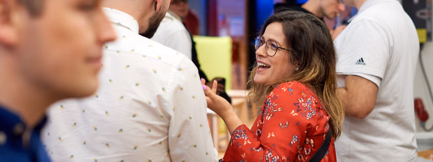 A woman laughing in conversation with other attendees at the ELC meetup in Brno