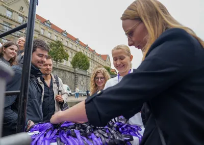ELC speakers and guests smiling as they pick up their name lanyards at the registration table before boarding the boat on the Vltava embankment in Prague