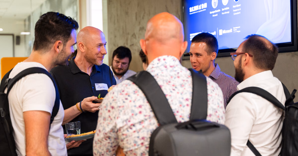 Engineering leaders talking in small groups with drinks and name stickers at an ELC meetup