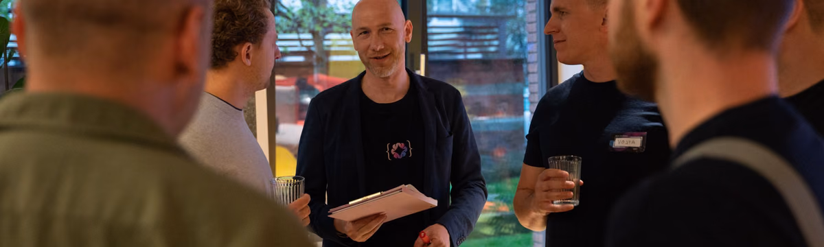 Engineering leaders talking over notes and drinks at an ELC meetup, the community behind the newsletter